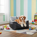 DreammyDoggie black and grey detachable dog car booster seat with a small dog resting inside on a colorful rug