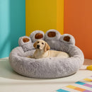 DreammyDoggie plush grey paw-shaped calming dog bed with a yellow Labrador resting inside against a colorful wall