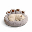 DreammyDoggie plush grey paw-shaped calming dog bed with a white puppy sleeping comfortably inside.