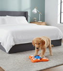 DreammyDoggie interactive dog puzzle toy with treat compartments being used by a golden retriever puppy on a rug