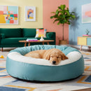 DreammyDoggie orthopedic anti-anxiety dog bed in teal with plush white vegan fur interior and a sleeping puppy