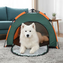 DreammyDoggie portable waterproof dog tent in green and orange with a white Samoyed dog resting inside on a carpet.